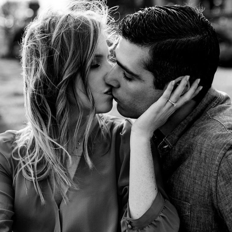 Black and White photo of engaged couple kissing